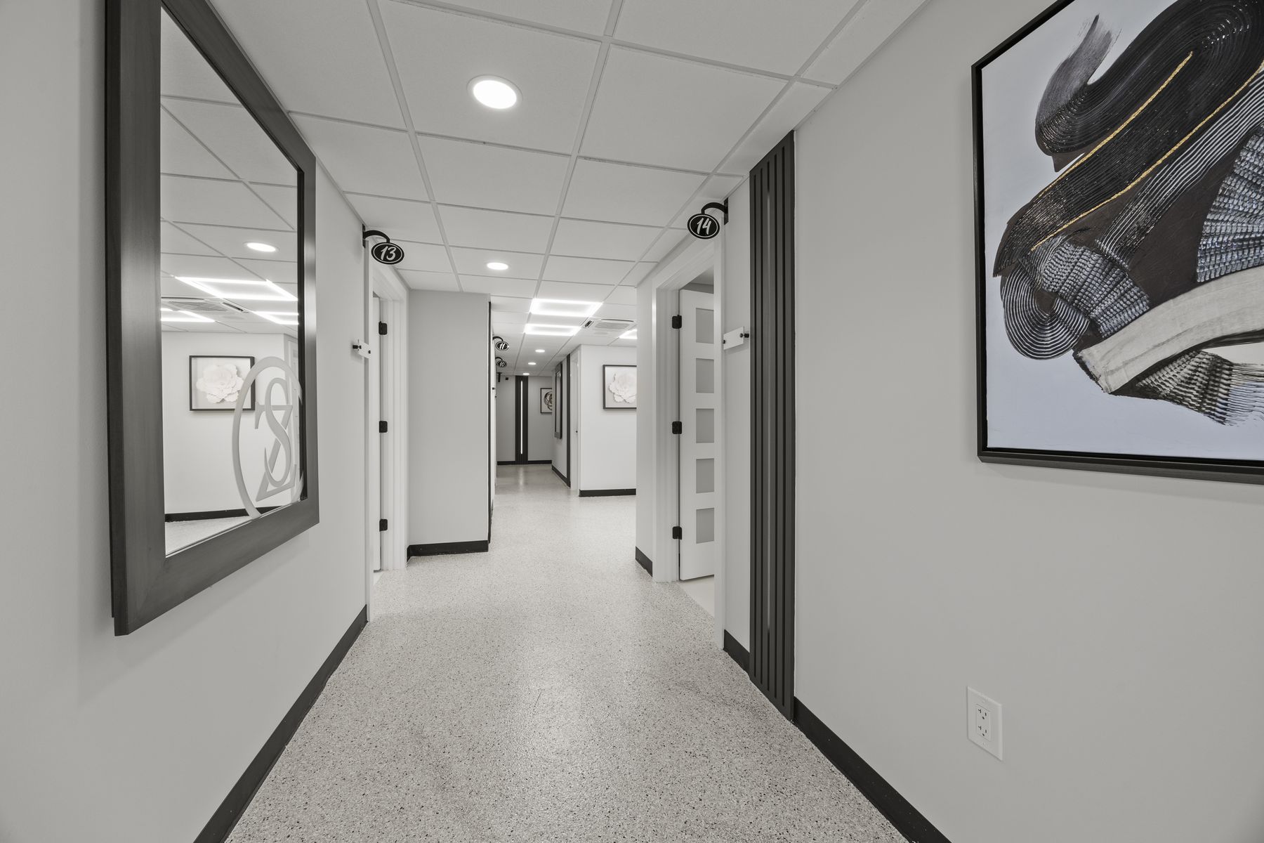 The Zaina Salons hallway, with numbered suite doors and a mirror etched with the ZS monogram