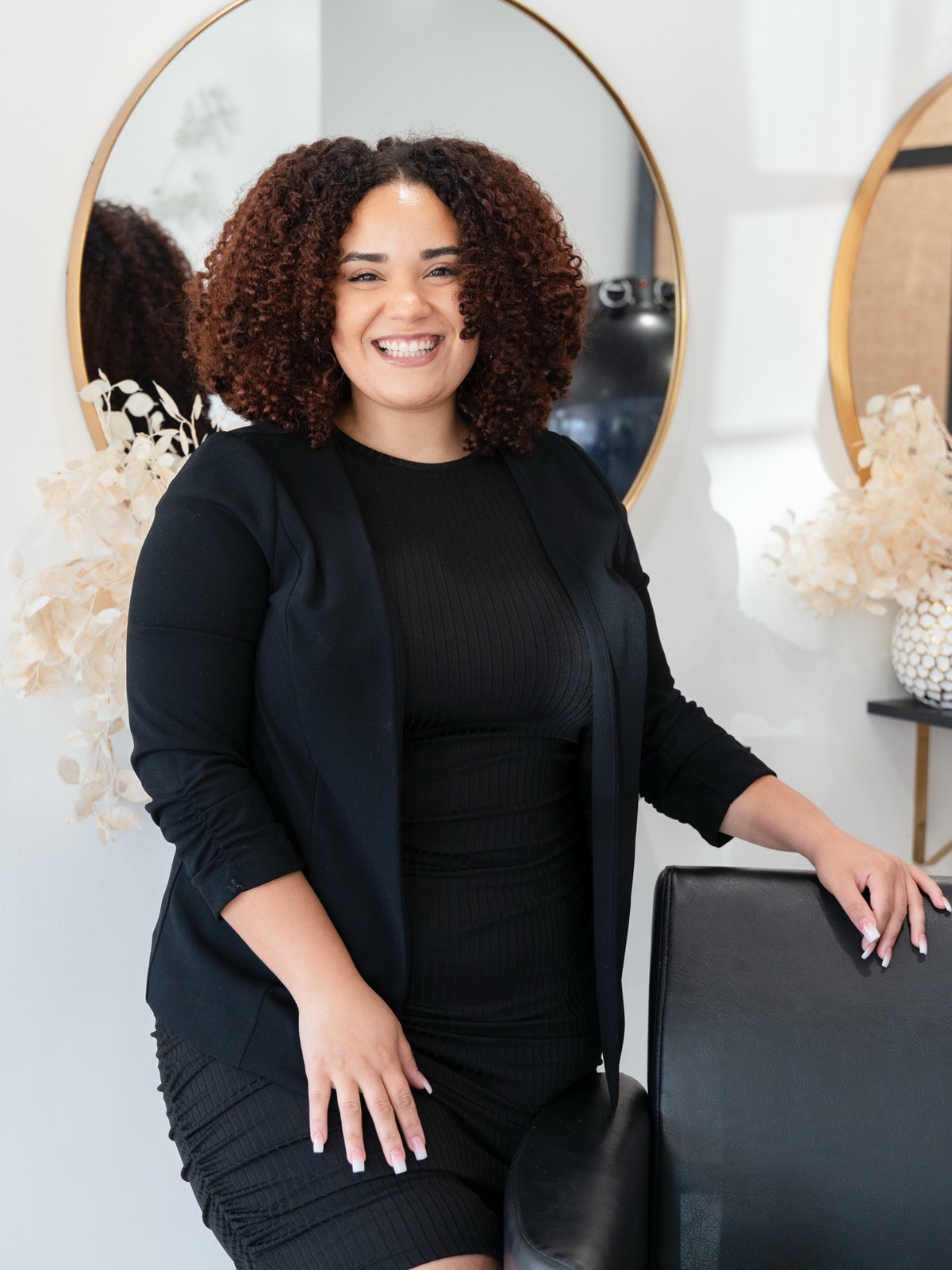 Cassidy Marie, curl specialist, smiling beside a styling chair